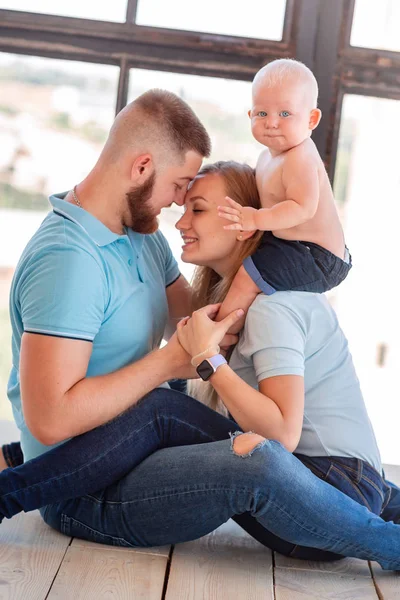 Jonge gelukkige familie met de baby binnenshuis — Stockfoto