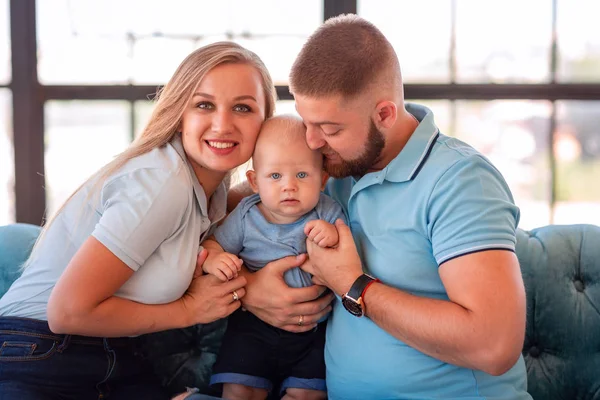 Jonge gelukkige familie met de baby binnenshuis — Stockfoto