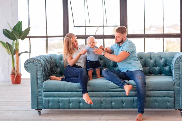 Young happy family with the baby indoors — Stock Photo, Image