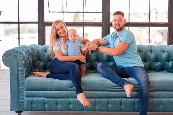 Young happy family with the baby indoors — Stock Photo, Image