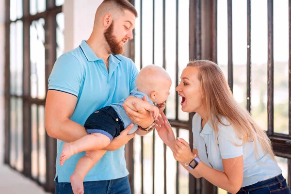 Young happy family with the baby indoors — Stock Photo, Image