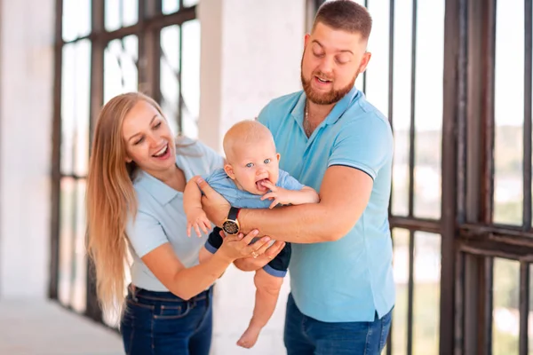 Jonge gelukkige familie met de baby binnenshuis — Stockfoto