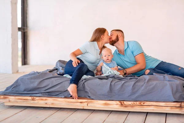 Jonge gelukkige familie met de baby binnenshuis — Stockfoto