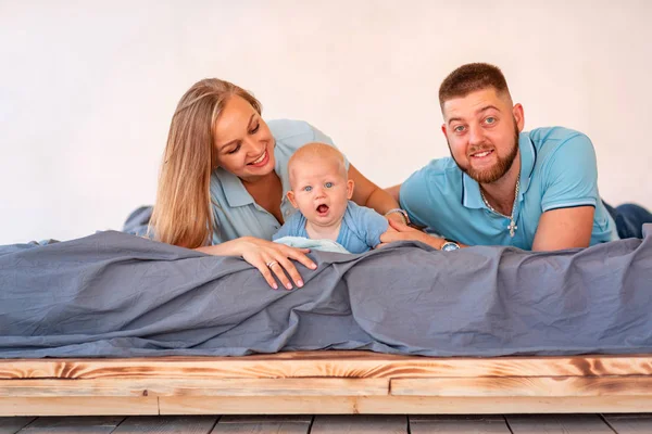 Young happy family with the baby indoors — Stock Photo, Image