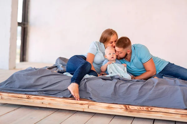 Young happy family with the baby indoors — Stock Photo, Image