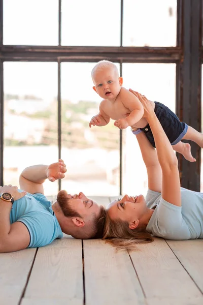 Young happy family with the baby indoors — Stock Photo, Image