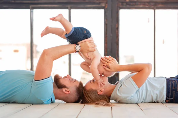 Young happy family with the baby indoors — Stock Photo, Image