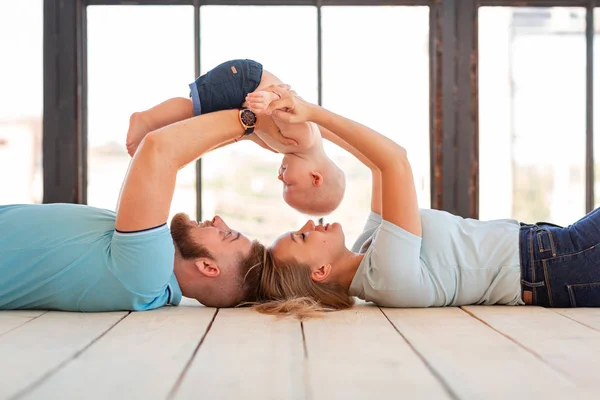 Jonge gelukkige familie met de baby binnenshuis — Stockfoto