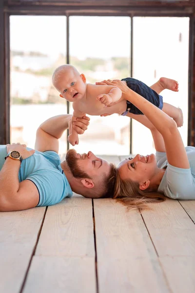 Young happy family with the baby indoors — Stock Photo, Image