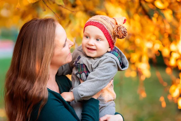 Mutlu anne ve bebek sonbaharda yaprakları — Stok fotoğraf