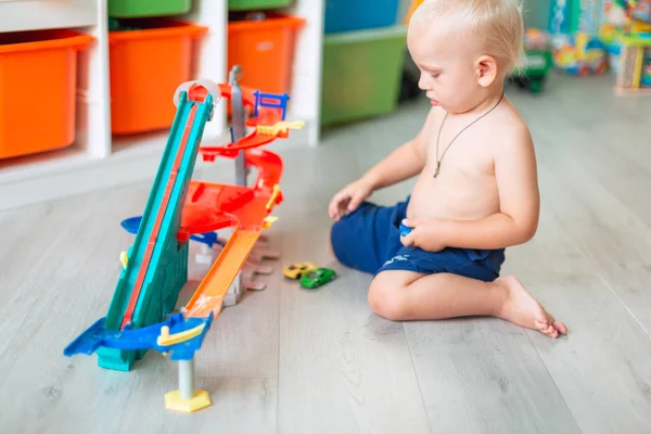 Милий хлопчик грає з іграшковими машинами на трасі — стокове фото