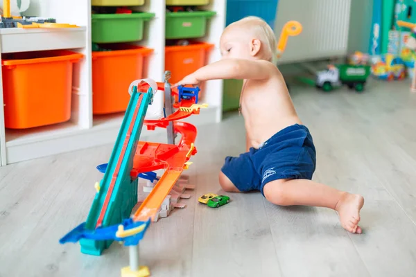 Aranyos kisfiú játszik a játék autók pályán — Stock Fotó