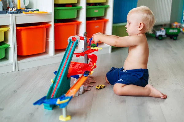 Söt Baby Boy leker med leksaksbilar på rätt spår — Stockfoto