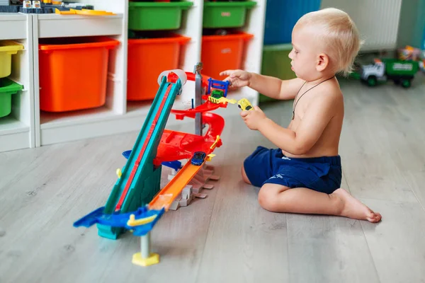 トラック上のおもちゃの車で遊ぶかわいい男の子 — ストック写真