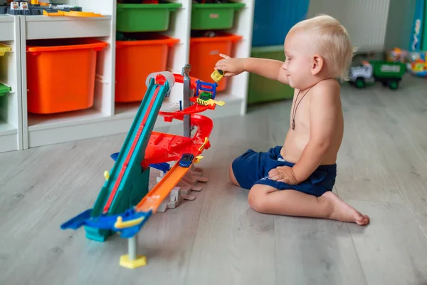 Söt Baby Boy leker med leksaksbilar på rätt spår — Stockfoto