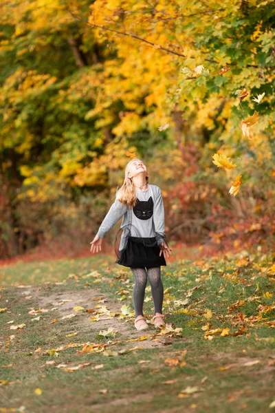 Bella bambina con foglie autunnali nel parco — Foto Stock