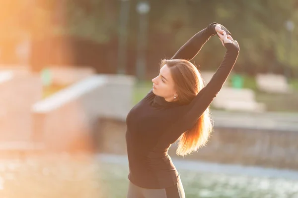 Fitness kobieta rozciągająca się na zewnątrz w środowisku miejskim — Zdjęcie stockowe