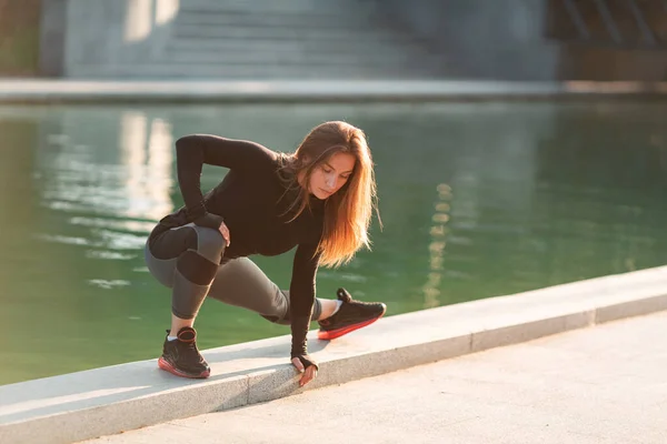 Fitness-Frau dehnt sich im Freien in urbaner Umgebung — Stockfoto