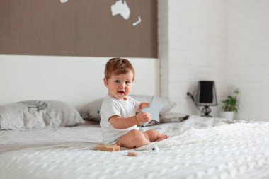 Mutlu bebek büyük bir yatakta oturuyor.