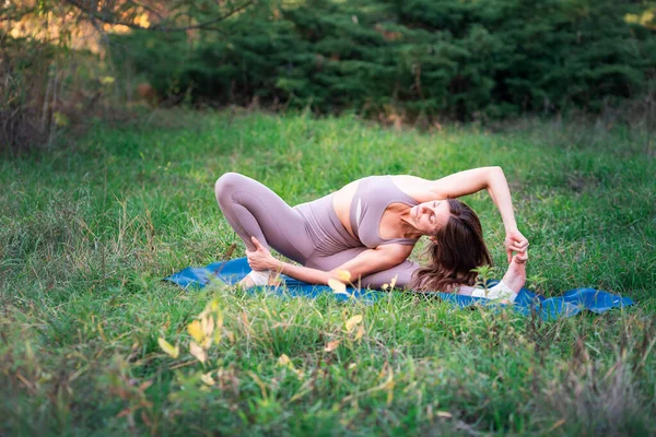 Mulher bonita praticando ioga no parque — Fotografia de Stock