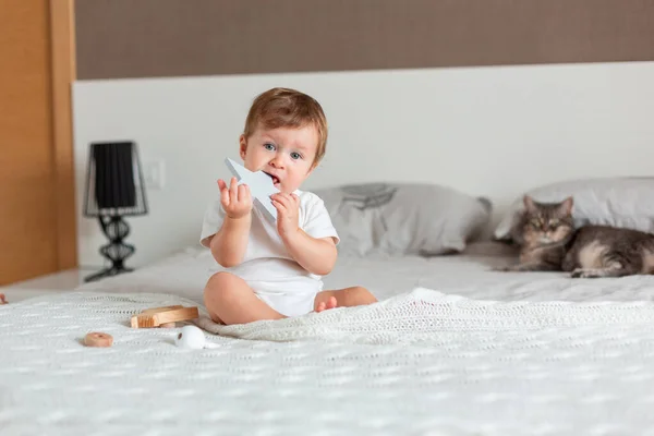 Glückliches Baby sitzt auf einem großen Bett — Stockfoto