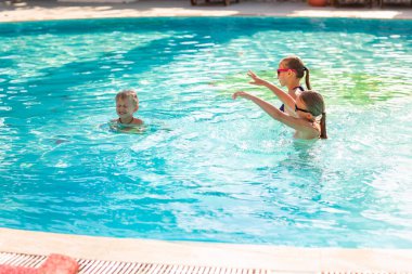 Tatil beldesinde havuzda eğlenen mutlu çocuklar
