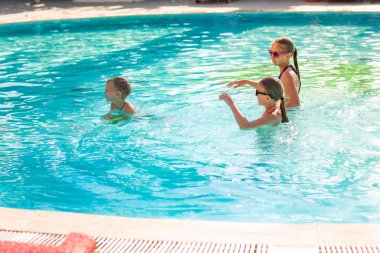 Tatil beldesinde havuzda eğlenen mutlu çocuklar