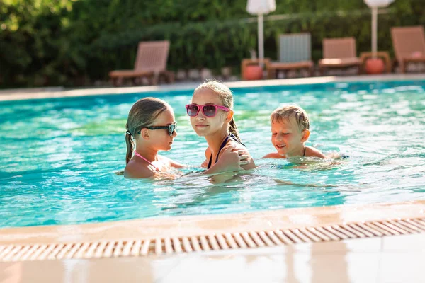 Tatil beldesinde havuzda eğlenen mutlu çocuklar