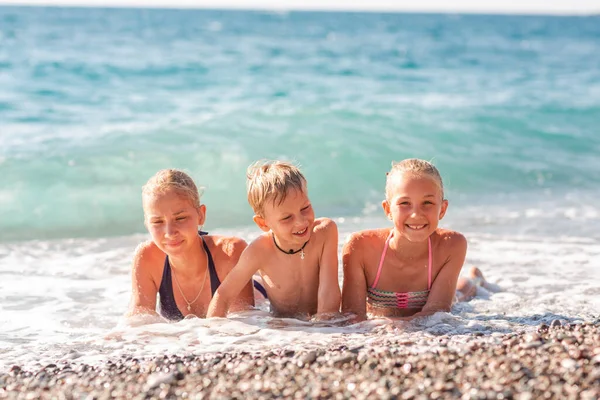 波の中で楽しんでいるビーチの幸せな子供たち — ストック写真