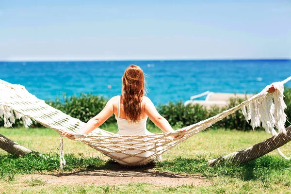 年轻女子在海滩上的吊床上休息 可以看到海景 — 图库照片