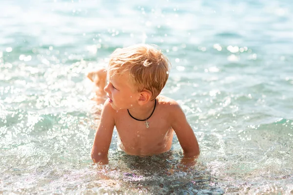 Szczęśliwy Chłopczyk Bawiący Się Deską Pływania Falach Nad Morzem — Zdjęcie stockowe