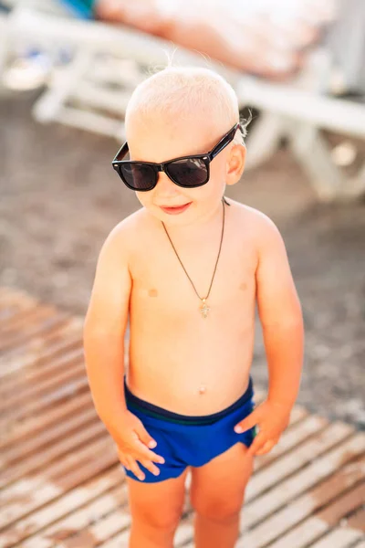 可爱的男婴戴着大太阳镜在海滩上摆姿势 — 图库照片
