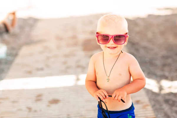 可爱的男婴戴着大太阳镜在海滩上摆姿势 — 图库照片