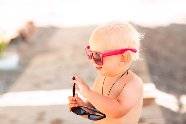 可愛いです赤ちゃん男の子ポーズで大きなサングラスでザビーチ — ストック写真