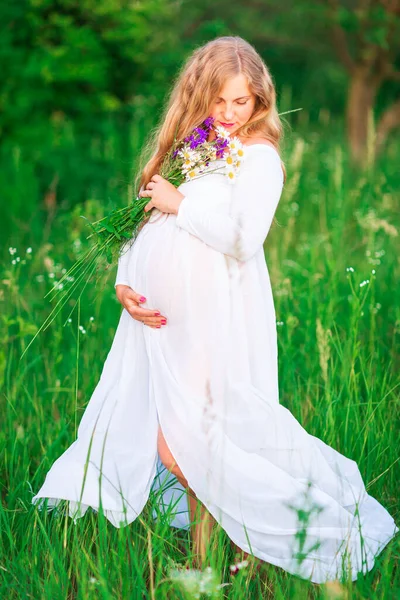 สาวสวยต งครรภ อนคลายในธรรมชาต ในว แดดสดใสท สวยงามก บสนามในพ นหล — ภาพถ่ายสต็อก