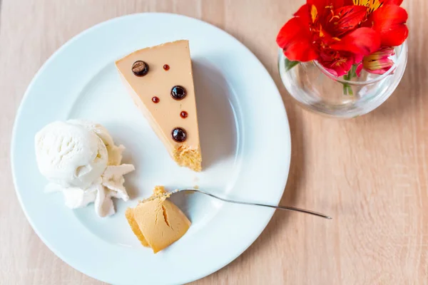 Ένα Κομμάτι Νόστιμο Cheesecake Καραμέλα Σερβίρεται Παγωτό Και Λουλούδια Στο — Φωτογραφία Αρχείου