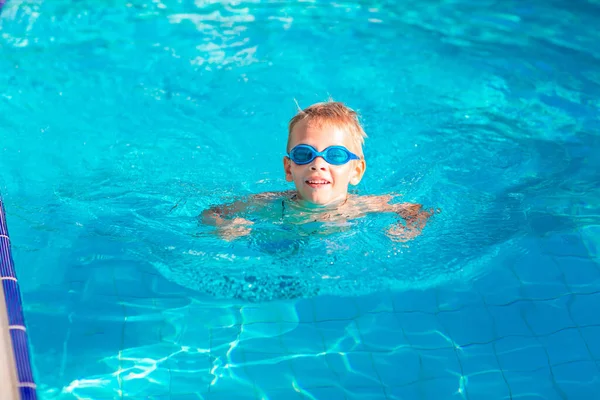 かわいいです幸せな男の子でゴーグル水泳とシュノーケリングでザスイミングプール — ストック写真