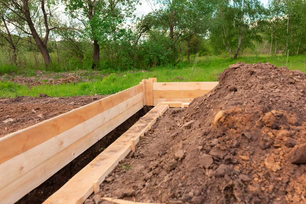 Wooden formwork for creating strip foundation for new house basis. Constructing house from the beginning concept — Stock Image Wooden Formwork Creating Strip Foundation New House Basis Constructing House Royalty Free Stock Photos