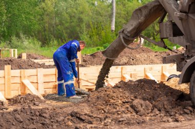 İnşaat işçisi temel çalışmalarına çimento ya da beton döşüyordu. Ev temelleri oluşturuluyor
