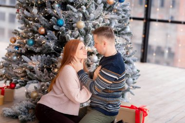 Mutlu çift evde Noel ağacının yanında eğleniyor.