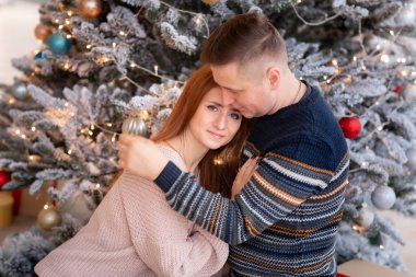 Mutlu çift evde Noel ağacının yanında eğleniyor.