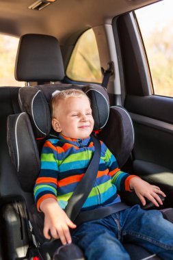 Arabada kemeriyle bebek koltuğunda oturan çocuk. Çocuk Araba Koltuğu Güvenliği