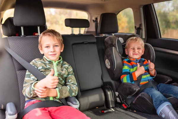 两个小男孩坐在一个汽车座位上 一个助推器座位在车里翘起 儿童汽车座椅安全 — 图库照片