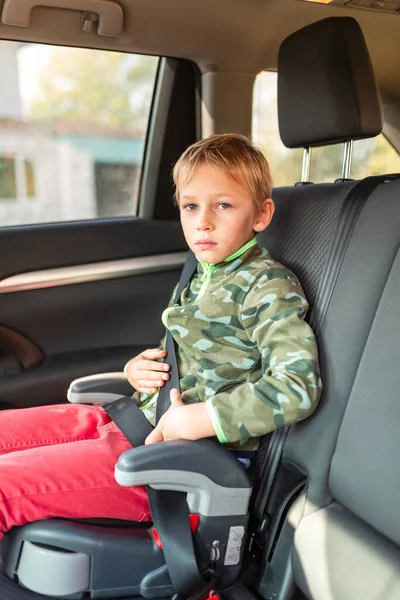 ブースター席に座っている男の子が車の中で座っていた チャイルドシートの安全性 — ストック写真