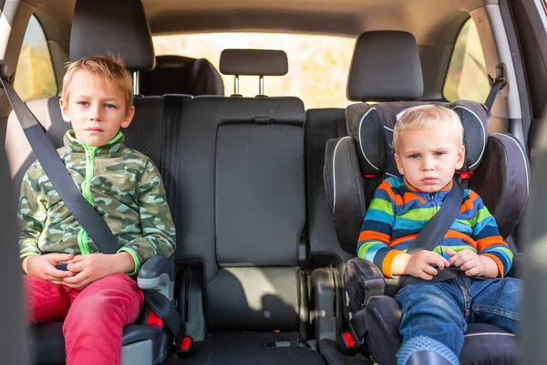 两个小男孩坐在一个汽车座位上 一个助推器座位在车里翘起 儿童汽车座椅安全 — 图库照片