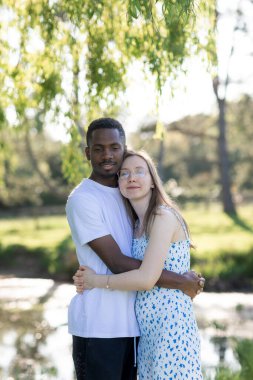 Genç bir çift, açık havada yaz gününün tadını çıkarıyor. Siyah bir adam ve beyaz bir kadın, doğal bir bahçe bahçesinde birlikte. Romantizm, sevgi ve çeşitliliği barışçıl, güneşli bir ortamda ifade ediyorlar.