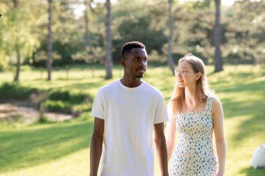 Genç bir çift, açık havada yaz gününün tadını çıkarıyor. Siyah bir adam ve beyaz bir kadın, doğal bir bahçe bahçesinde birlikte. Romantizm, sevgi ve çeşitliliği barışçıl, güneşli bir ortamda ifade ediyorlar.