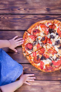 İtalyan pizzası biberli, domatesli, zeytinli ve fesleğenli ahşap masa. Kopyalama alanı olan üst görünüm