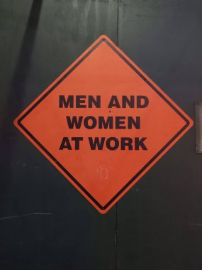 İş yerindeki erkek ve kadınlar hakkında turuncu ve siyah inşaat tabelası