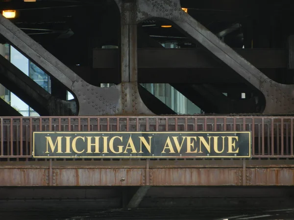 Michigan Avenue Street Sign On The Loop structure in Chicago, Rectangular street sign in black and golden letters posted on rusty metallic structure